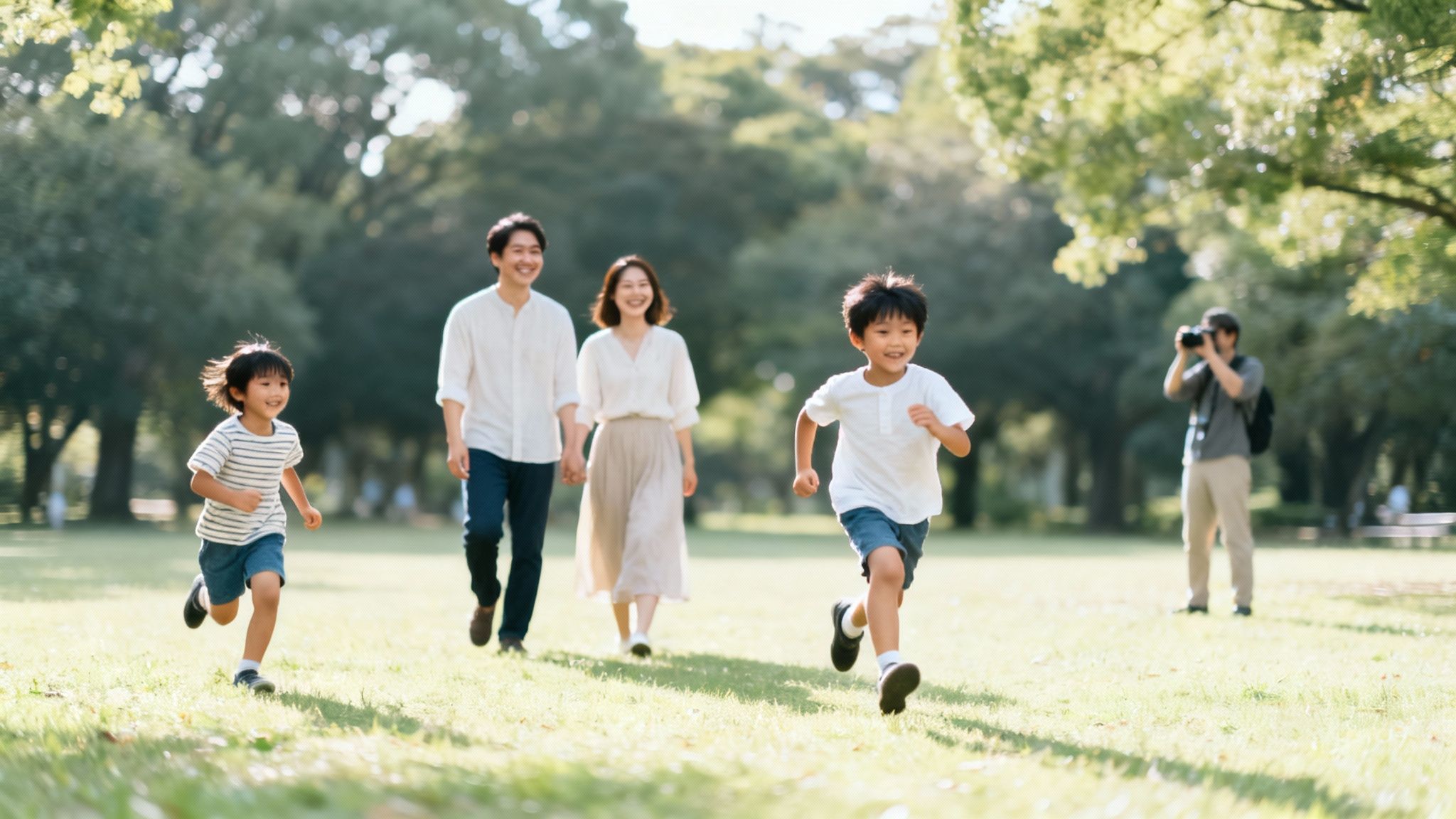 A happy family running and walking in a sunny park with a photographer.
