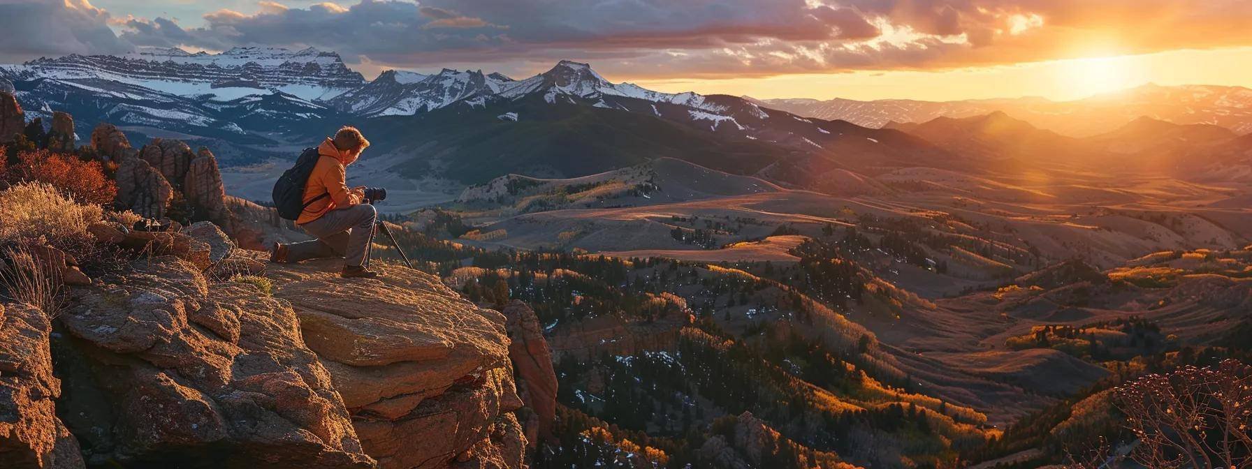 a photographer kneeling on a rocky ledge, capturing the vibrant sunset over the majestic colorado mountains.