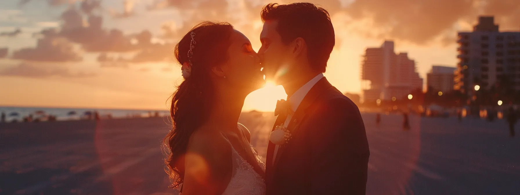 a bride and groom sharing a spontaneous, joyful kiss on south beach at sunset, captured by a candid wedding photographer.